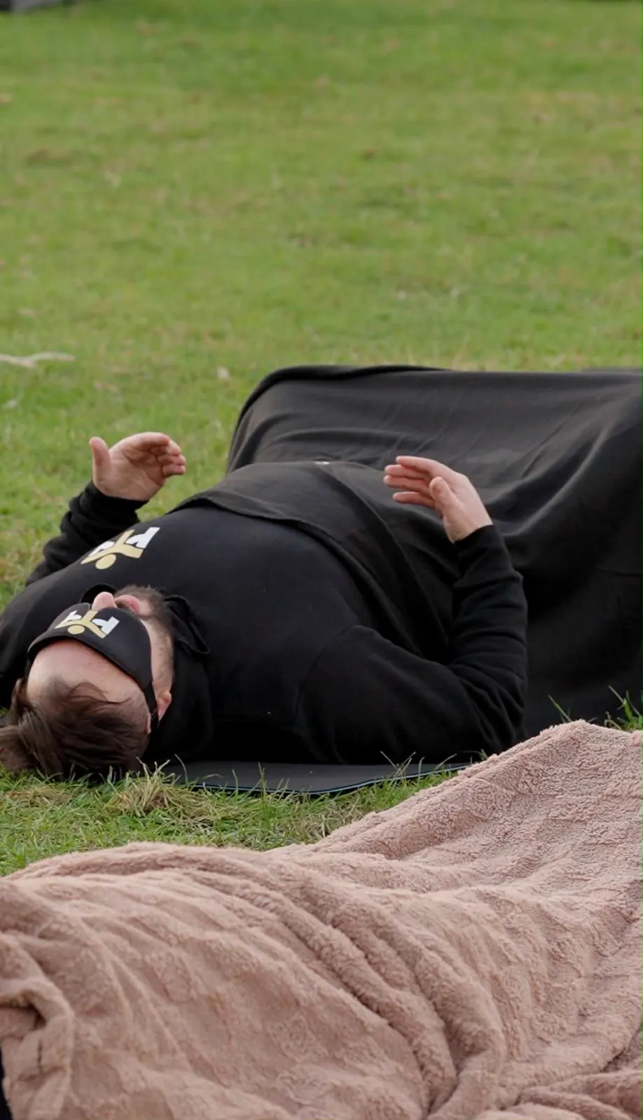 A man resting on the grass during breathwork